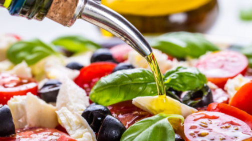 Caprese. Caprese salad. Italian salad. Mediterranean salad. Italian cuisine. Mediterranean cuisine. Tomato mozzarella basil leaves black olives and olive oil on wooden table. Recipe - Ingredients