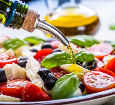 Caprese. Caprese salad. Italian salad. Mediterranean salad. Italian cuisine. Mediterranean cuisine. Tomato mozzarella basil leaves black olives and olive oil on wooden table. Recipe - Ingredients